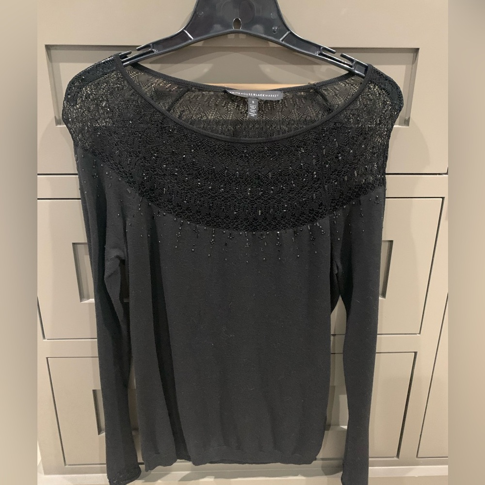 Whit house black market black sweater with beading and lacy details.